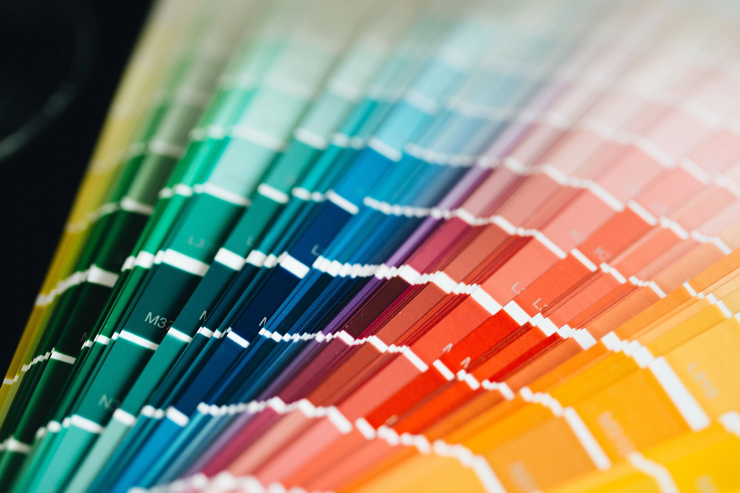 Karl Hansel Inh – Baudekoration – Ein aufgefächertes Farbmusterbuch, das eine lebendige Farbpalette von Grün und Blau bis hin zu Rot, Orange und Gelb zeigt.